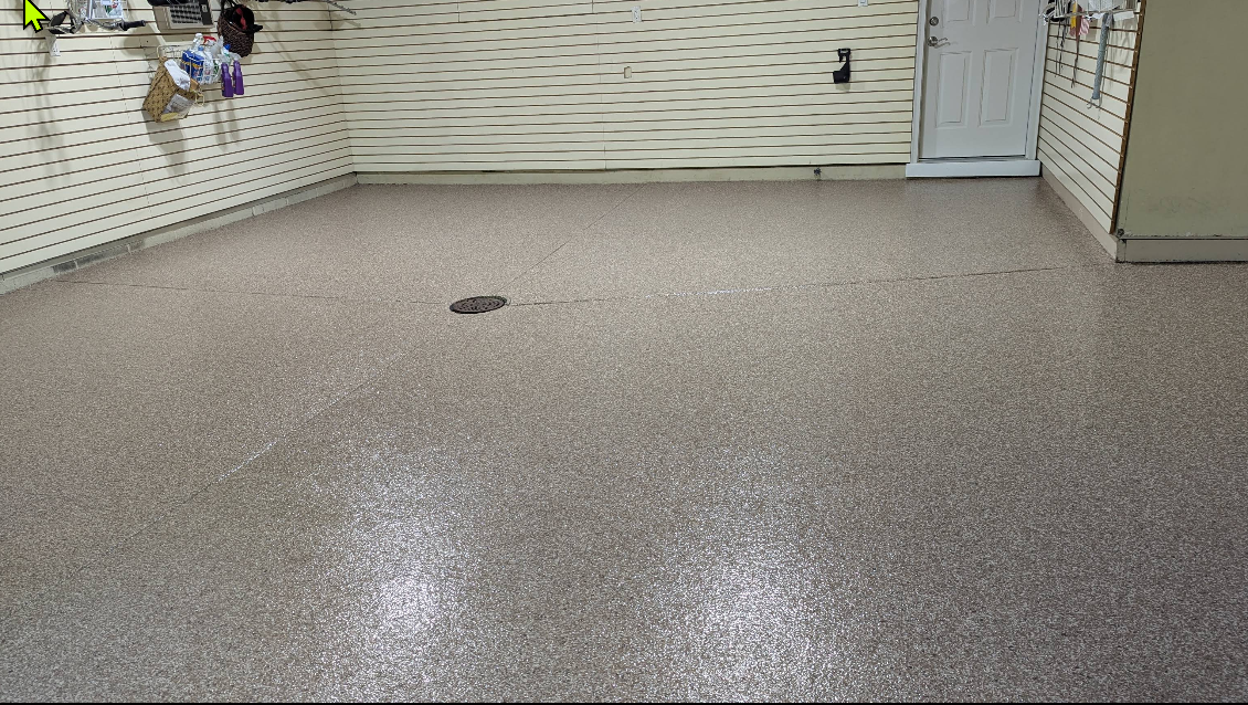 After: smooth, glossy tan-and-gray epoxy flake floor in the same Strongsville garage, clean and bright
